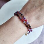 Bransoletka znak zodiaku Skorpion - Ametyst, Hematyt, Turmalin czarny, Granat i Jadeit Rubinowy 8 Delikatna bransoletka z fasetowanych kamieni naturalnych na kobiecym nadgarstku.