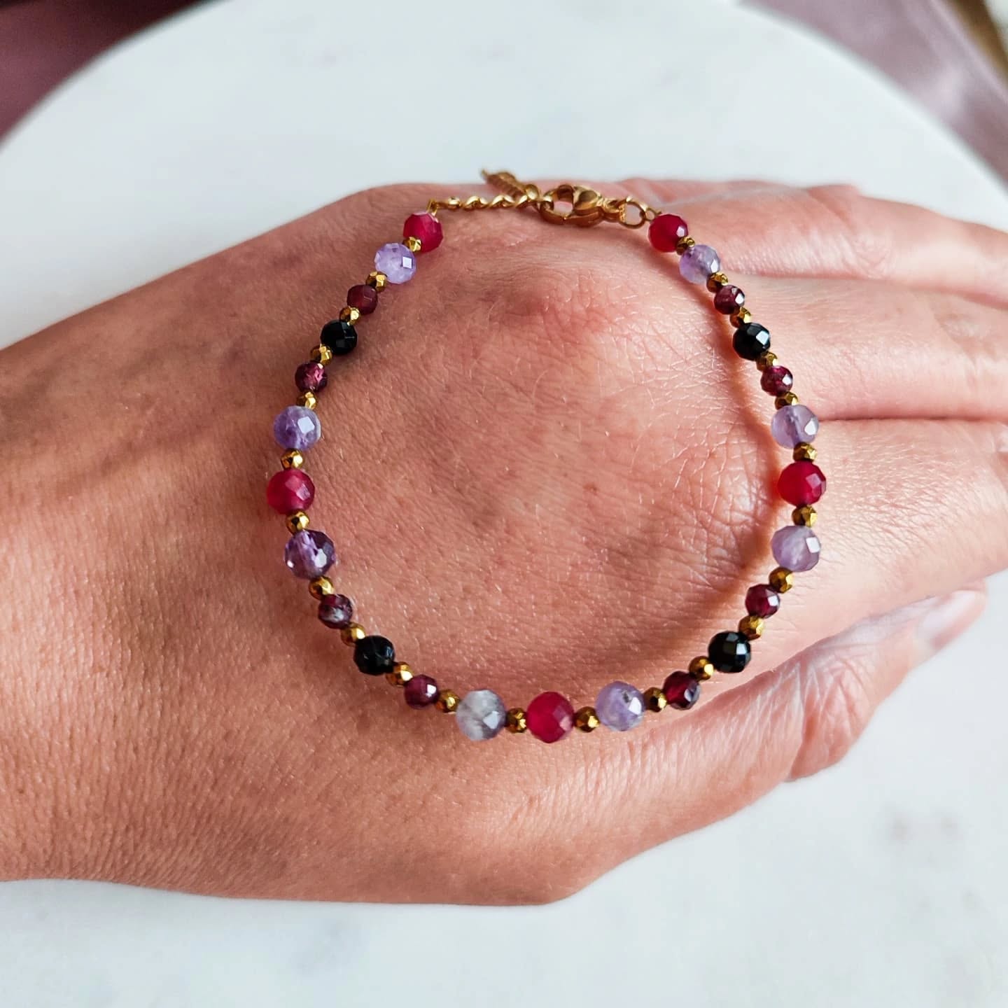 Kolorowa Bransoletka z Kamieni Naturalnych na Dłoni Kolorowa bransoletka z kamieni naturalnych na dłoni, elegancka biżuteria handmade.