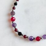 Bransoletka znak zodiaku Skorpion - Ametyst, Hematyt, Turmalin czarny, Granat i Jadeit Rubinowy 6 Elegancki naszyjnik handmade z fasetowanych kamieni naturalnych na jasnym tle.