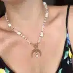 Biały naszyjnik z kamieniem księżycowym i lunulą 1 Naszyjnik boho z muszelek i pereł ze złotą zawieszką w kształcie księżyca.