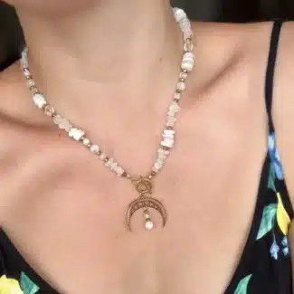 Naszyjnik boho z muszelek i pereł ze złotą zawieszką w kształcie księżyca.