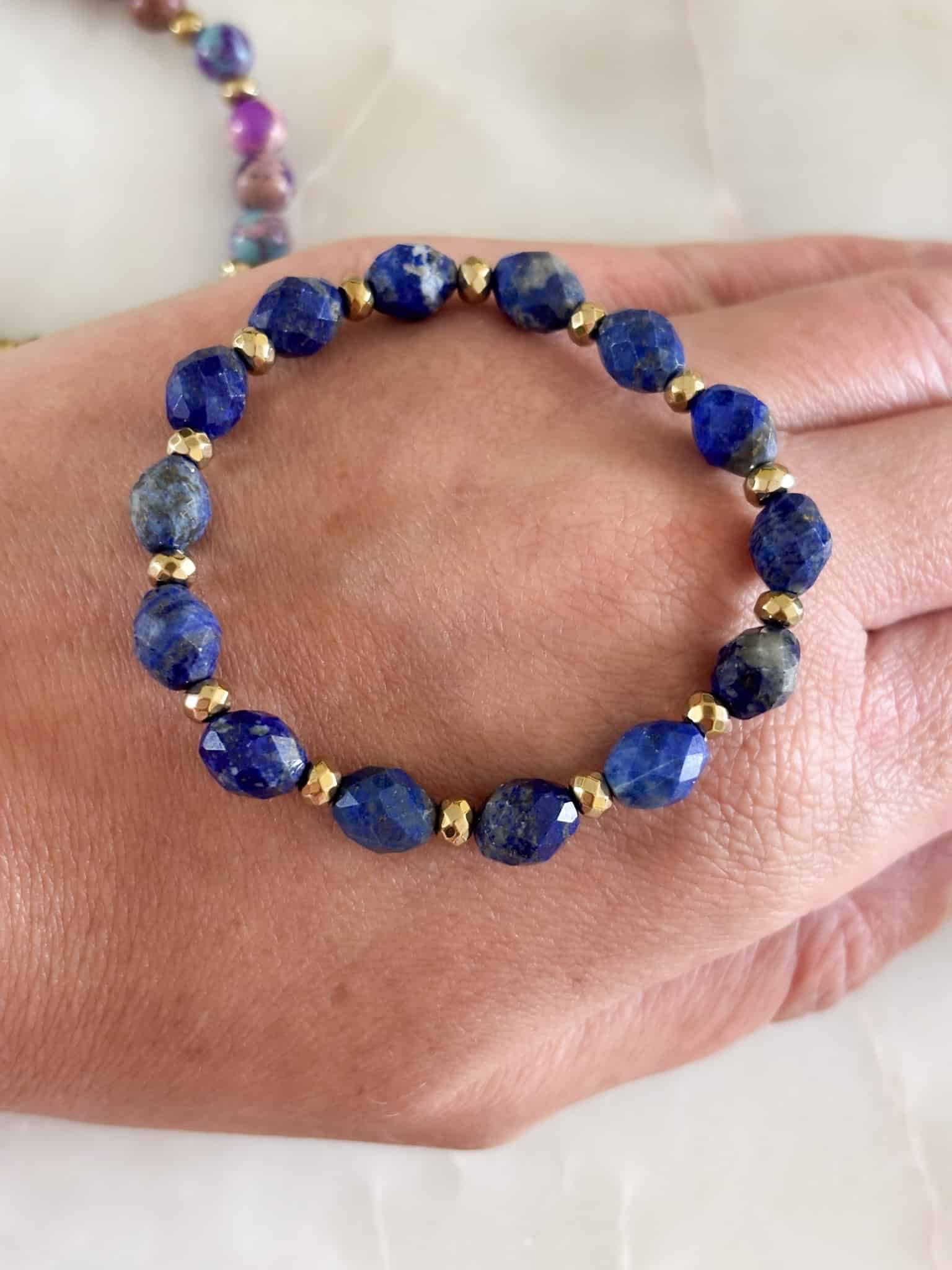 Ręcznie robiona bransoletka z kamieni naturalnych lapis lazuli na dłoni.