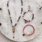 Bransoletka 7 czakr z serduszkiem 16 Zestaw biżuterii handmade boho: kolorowy naszyjnik i bransoletki na marmurowej tacy.