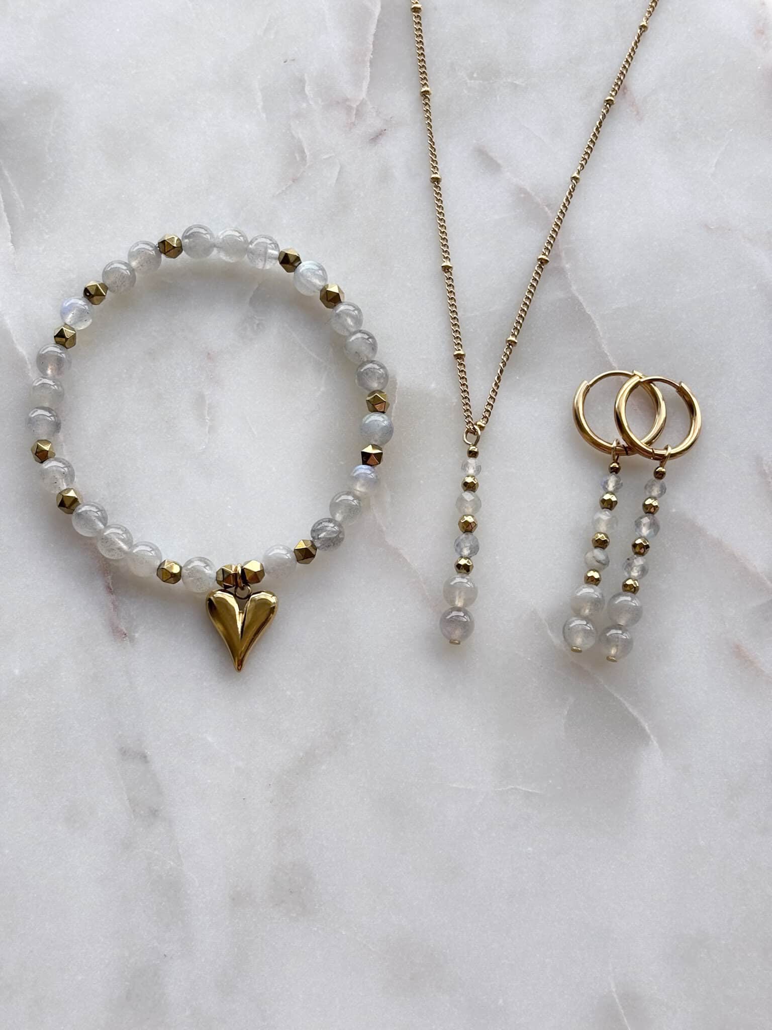Delikatny złoty komplet biżuterii handmade: naszyjnik, bransoletka z sercem i wiszące kolczyki.