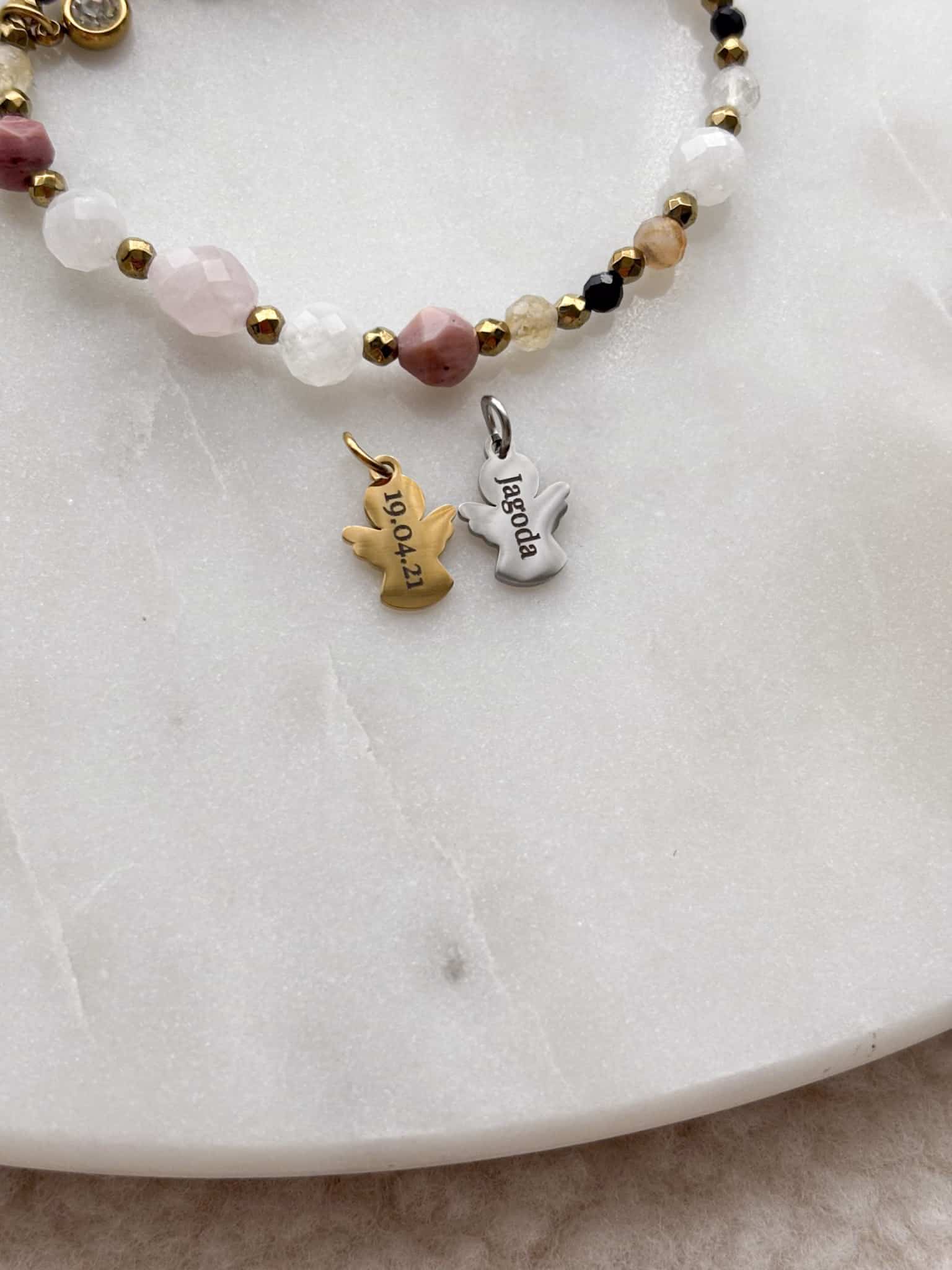 Bransoletka z koralików i personalizowane zawieszki w kształcie aniołków z grawerem.