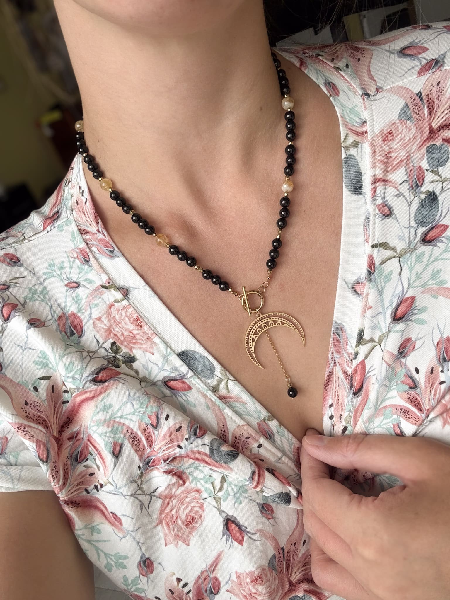 Czarny naszyjnik boho z księżycem Czarny naszyjnik boho z zawieszką w kształcie złotego księżyca na dekolcie.