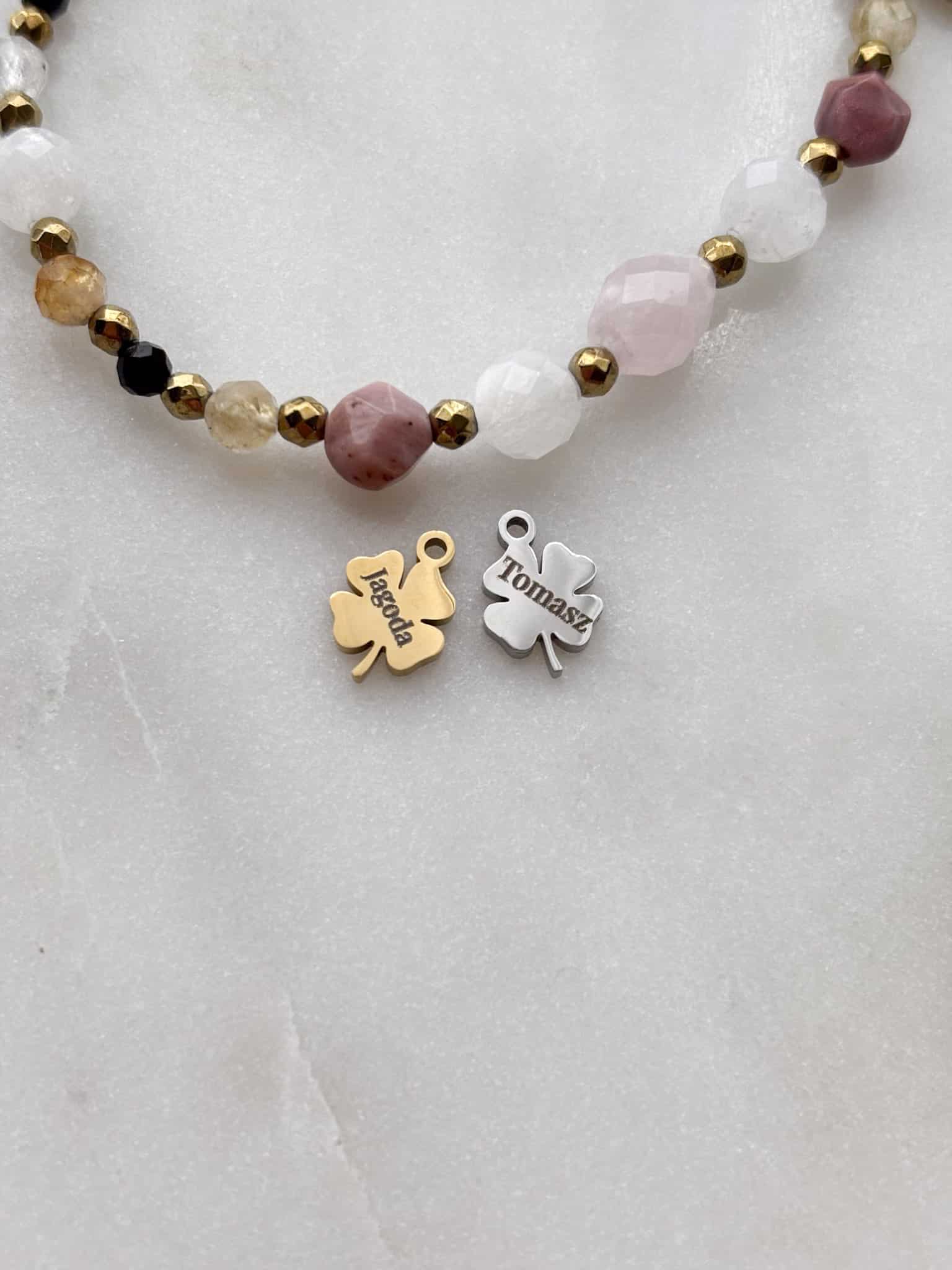 Personalizowana bransoletka z kamieni naturalnych z grawerowanymi zawieszkami w kształcie koniczynek.